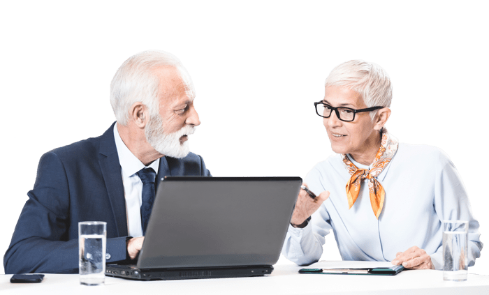 an older pair of professionals discussing in front of a laptop